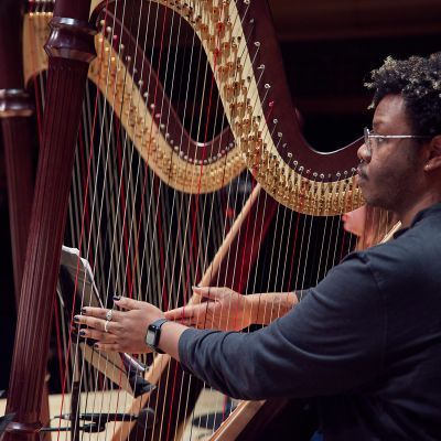 Student playing the harp